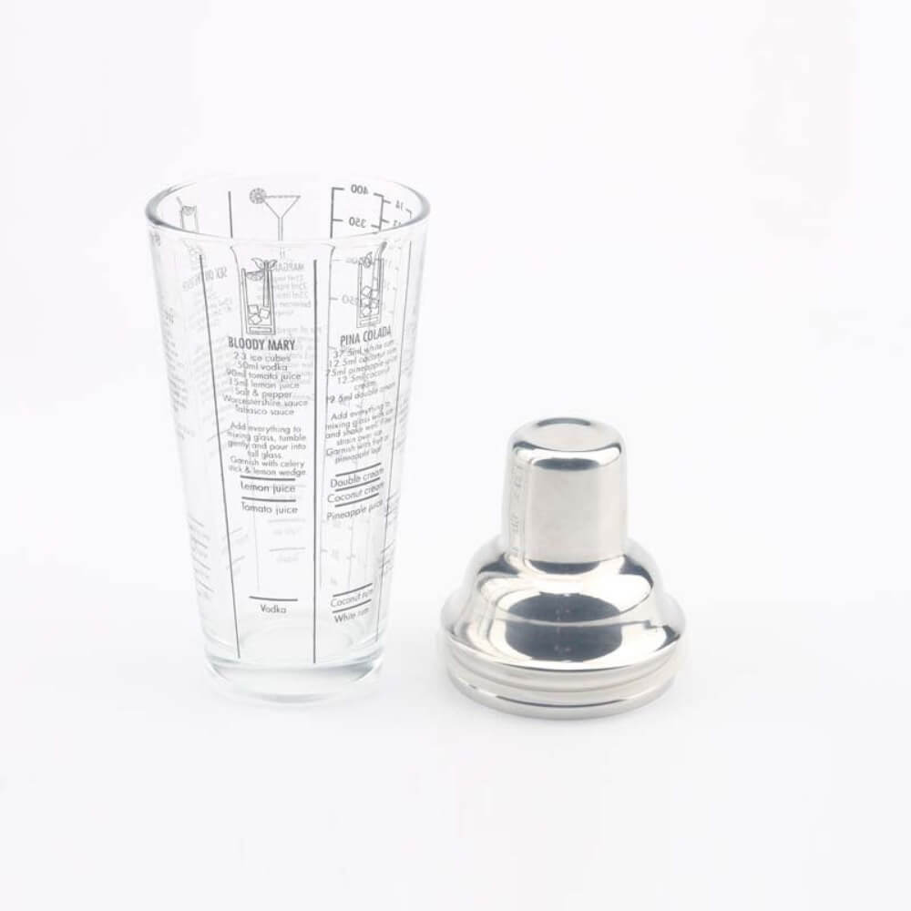 The Glass Cocktail Shaker with Classic Recipes and Measurements on the side. The strainer and cap sitting next to it.